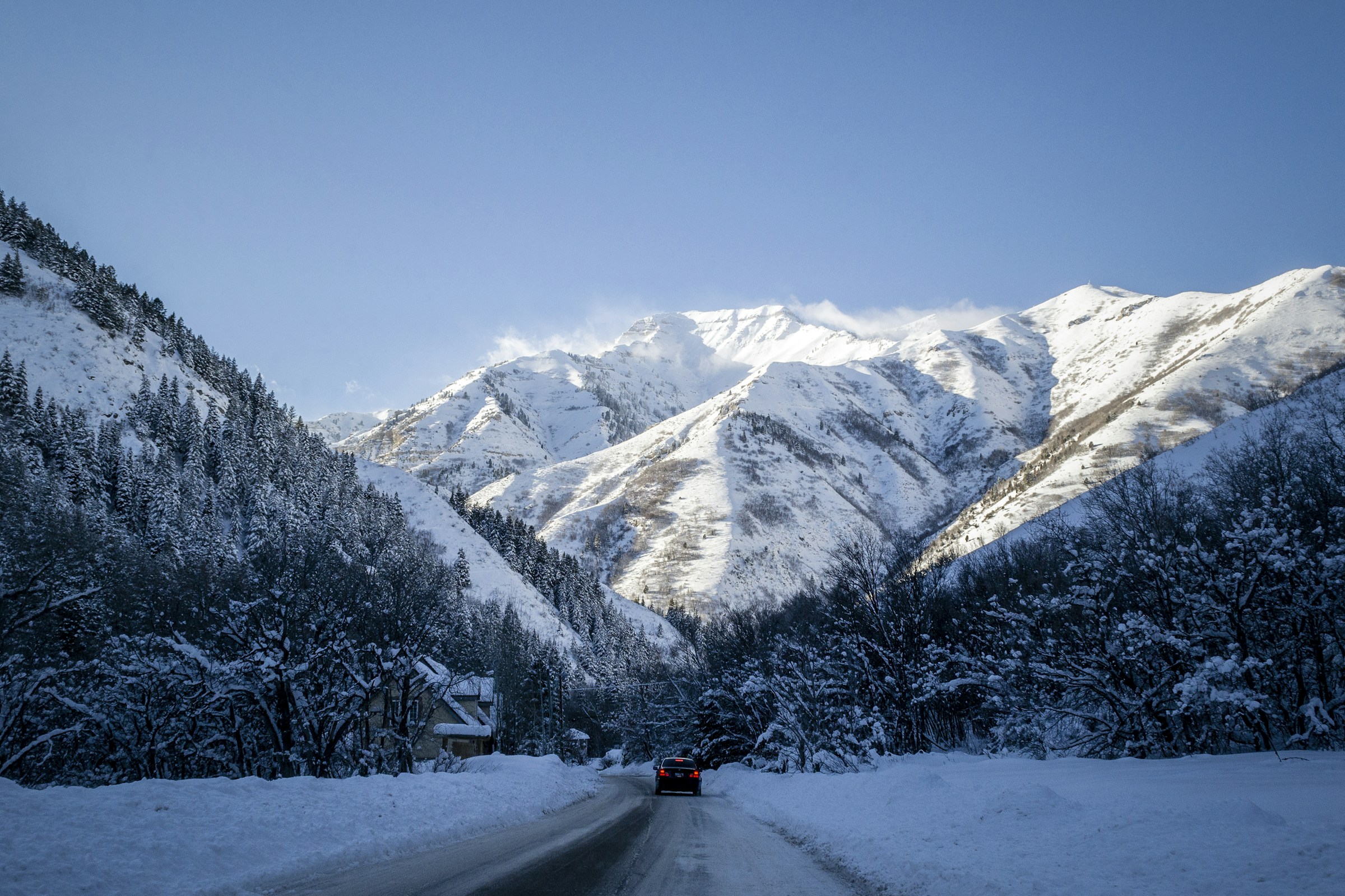 Vehicle traveling through snowy mountains during winter