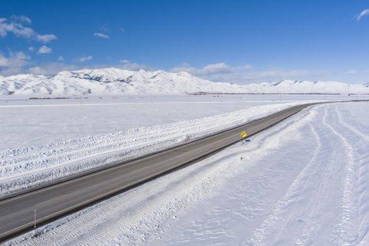 Cleared road winding through a snow-covered mountain landscape